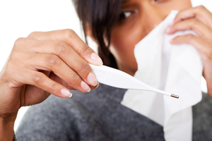 Young sick woman checking her temperature , isolated